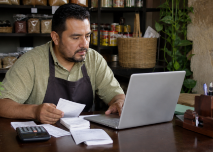 Comerciante revisa una factura electrónica y archivos digitales en una computadora