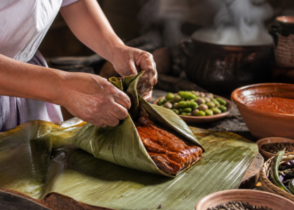 Mixiotes de Hidalgo recién cocidos al vapor junto a tortillas, salsas y manos de una cocinera tradicional